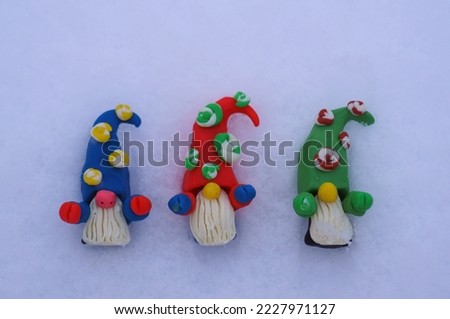 Figures of colorful dwarfs on a background of snow. Christmas decorations. Christmas toys.