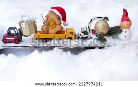 model of toy metal excavator, truck, warehouse loader, souvenir snowman standing on snow. festive atmosphere of Christmas, New Year holidays. concept of christmas greetings for construction business