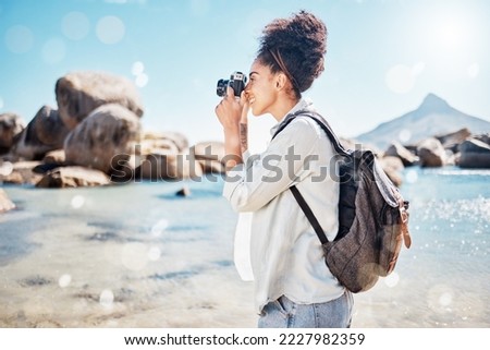 Photography camera, ocean and photographer shooting outdoor beach, sea or nature beauty picture. Blue sky flare, peace or sunshine freedom for tourist black woman on summer travel adventure in Brazil