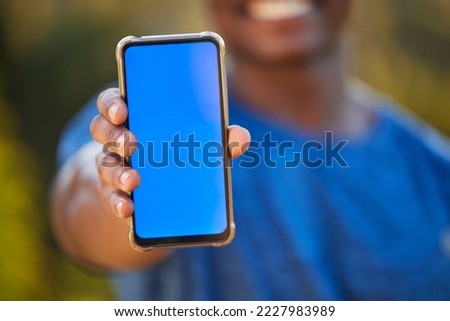 Phone, mockup and blue screen in the hand of a black man outdoor for exercise or fitness tracking. Marketing, advertising and green screen with a male athlete holding mobile display to show an app