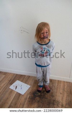 Unsupervised child making mess with mother's make up, kid messed cosmetics all around and painted his face Royalty-Free Stock Photo #2228000069