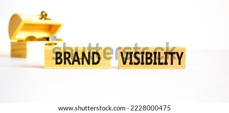 Brand visibility symbol. Concept words Brand visibility on wooden blocks. Beautiful white table white background. Wooden chest with coins. Business branding and brand visibility concept. Copy space.