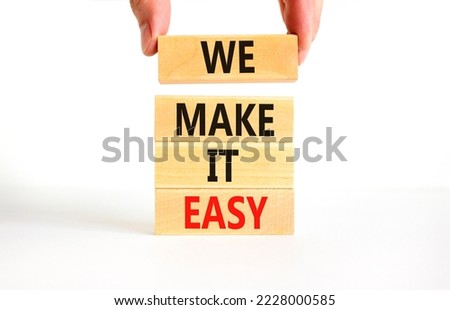 We make it easy symbol. Concept words We make it easy on wooden cubes. Beautiful white table white background. Businessman hand. Business motivational we make it easy concept. Copy space.