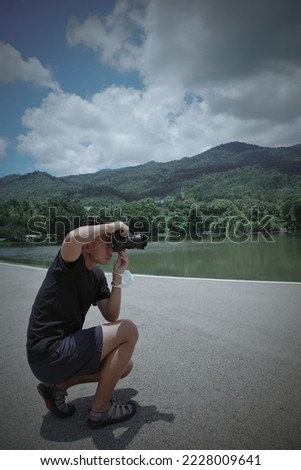 Young man traveller knee sitting and using camera