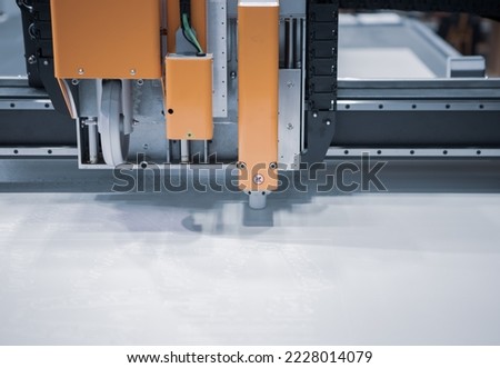 Digital die cut machine cutting plastic sheet. Industrial manufacture. Royalty-Free Stock Photo #2228014079