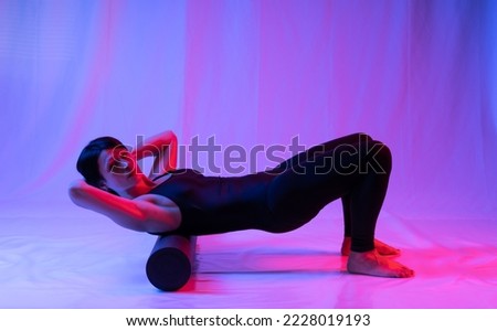 Athletic woman in high school, swimsuit and leggings, doing yoga, push-ups or push-ups, falancasana, plank pose variation, beautiful girl exercising at home or in a yoga studio