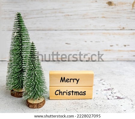Merry Christmas Greeting Card with  Green Pine Trees on White Wooden Background 
