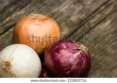 Onions of different qualities on a wooden bench 