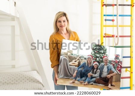woman holding a photo canvas with a picture of christmas.