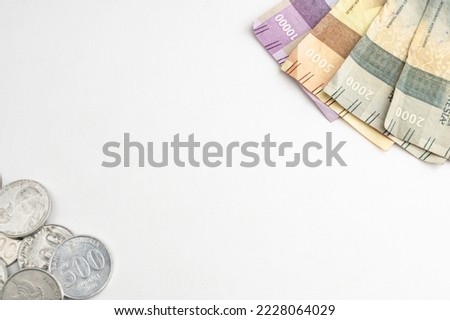 Indonesian rupiah paper and coin money on white plain background and empty negative for copy and text space. Uang receh Rupiah Indonesia official currency of Indonesia.