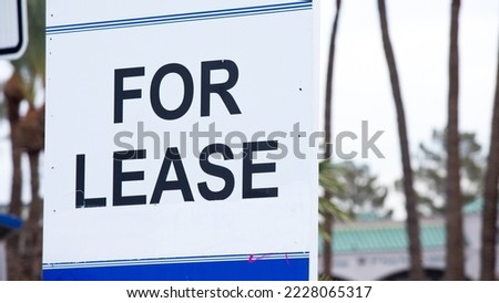 "For Lease" sign at a vacant commercial property written in all caps. Standard black font on white background with blue borders. Found in Las Vegas, NV, USA.