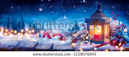 Christmas Lantern With Decoration On Snow Table - Snowy Candle Light And Abstract Defocused Landscape