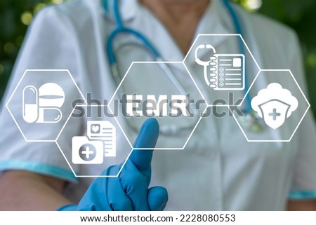 Medicine, information technology, healthcare concept. Nurse using virtual touchscreen presses abbreviation: EMR. EMR Electronic Medical Records. Royalty-Free Stock Photo #2228080553