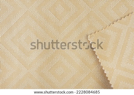 Texture of fabric for furniture upholstery in beige color with rectangular patterns or rhombuses. Texture of wear-resistant fabric for furniture production, close-up, top view. Royalty-Free Stock Photo #2228084685
