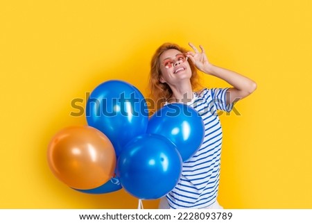 party girl with balloon in sunglasses. glad girl hold party balloons in studio. girl with balloon
