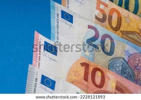 Different euro banknotes in a row close up, blue background for business finance topics. World money concept, inflation and economy concept. Currency close up in detail.