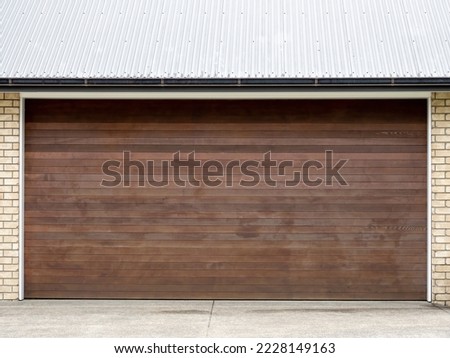 View of wooden raised panel garage door with white trim. Copy space stock photo.