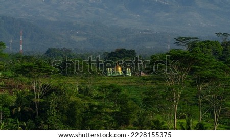 Beautiful rural landscape of Indonesia with view of golden mosque in the middle of rice field and huge mountain on the background - Kajoran village, Indonesia