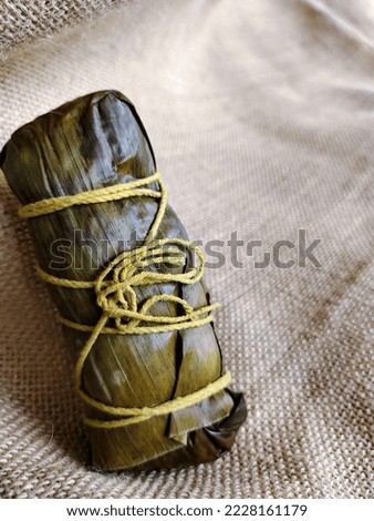 Traditionally wrapped rice dumplings or zongzi. Isolated on a burlap texture background. Top view