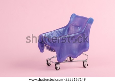 supermarket cart with slime on pink background. Creative halloween layout