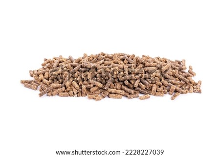 Sunflower granulated feed  on white background, close-up. Pile of sunflower meal pellets on white background. Heap of animal feed pellets  on white background.
