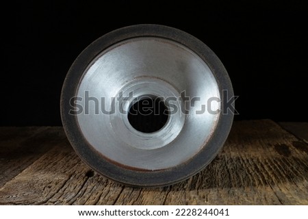 A locksmith tool for grinding on an old wooden table. Industrial objects on a dark background
