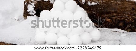 pyramid or a pile of perfect snowballs on frosty winter day in forest or garden outdoor. snowy winter season and fun entertainment in nature. banner