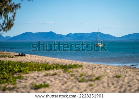 white sand beach in queensland Australia with boats and tourism in summer