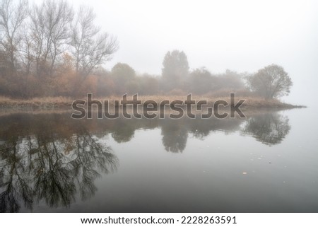 Misty morning and reflection on the water of lake.