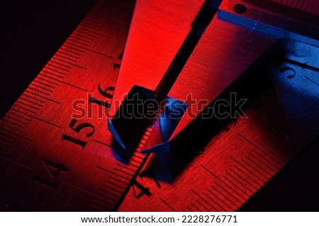 caliper and metal rulers illuminated in red and blue. close-up
