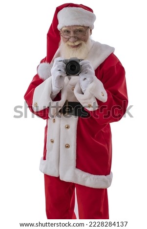 Xmas Santa Claus photographer with camera taking a photo. Emotional senior male model old man with a natural white beard on white isolated background. Joyful character for Christmas season advertising