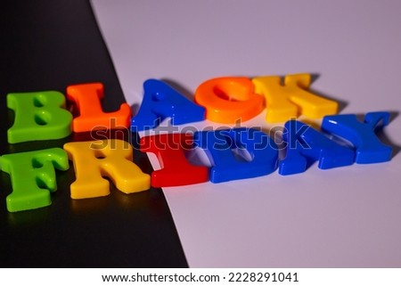Plastic letters and the inscription Black Friday and discounts are placed on a black and white background.