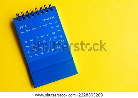 September 2023 blue desk calendar on yellow cover background. Royalty-Free Stock Photo #2228305283