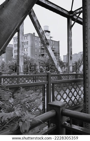 Black and white image of a detail of metal, industrial bridge and brick industrial building in downtown Denver, Colorado, USA