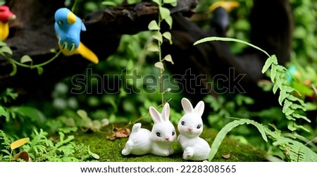 Closeup of Rabbits Stucco Doll with natural background for design and decoration in the garden at thailand.