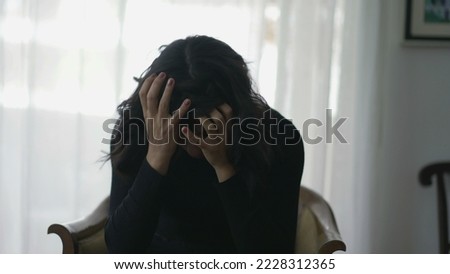 Woman covering face in shame suffering from emotional pain Royalty-Free Stock Photo #2228312365