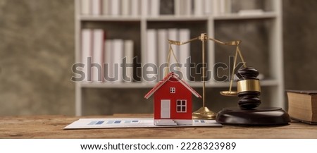 scales of justice, gavel and small wooden toy house, working with documents, signing contract agreements. Real estate law concept.