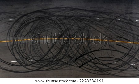 Top view tire tracks texture and background, Asphalt texture with line and tire marks, Automobile automotive tire skid mark on race track, Abstract texture car drift tire skid mark.