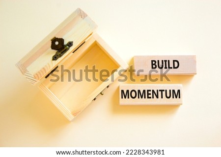 Build momentum symbol. Concept words Build momentum on wooden blocks. Beautiful white table white background. Empthy wooden chest. Business and build momentum concept. Copy space.