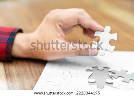 white jigsaw puzzle piece for complete connection concept in hand of business man for success solution and strategy