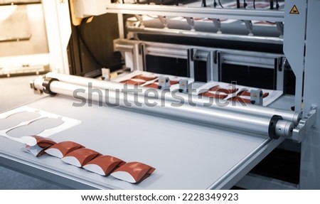Digital cutting machine. Food folding packaging process on digital cutting machine. Printing industry. Royalty-Free Stock Photo #2228349923