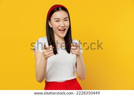 Amazing confident young girl woman of Asian ethnicity 20s years old wears white t-shirt pointing index fingers camera on you motivating encourage isolated on plain yellow background studio portrait Royalty-Free Stock Photo #2228350449