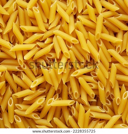 Homemade Raw Dry Mini Penne Pasta background Royalty-Free Stock Photo #2228355725