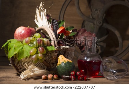 Picturesque autumn composition with  basket, fruits, pumpkin, wine, and wine glass