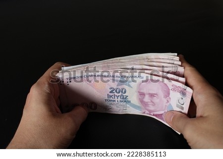 Hand of man counting Turkish money. Turkish lira banknotes. Paper currency of Turkey. 200, 100, 50 Turkish liras. black background. Economy and finance themed photo.