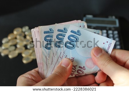 Hand of man counting Turkish money. Turkish lira banknotes. Paper currency of Turkey. 200, 100, 50 Turkish liras. black background. Economy and finance themed photo. Royalty-Free Stock Photo #2228386021