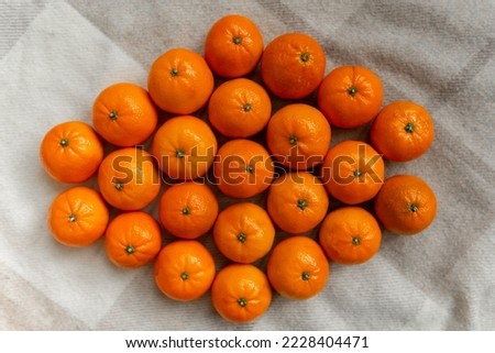 Basket with tangerine or orange fruit on a gray plaid background.