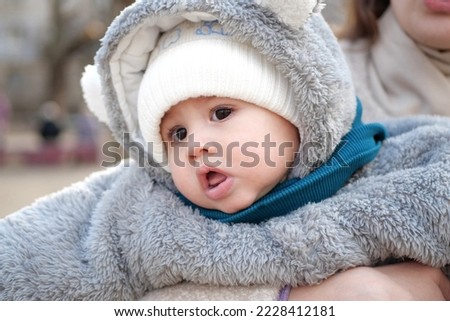 Happy little baby boy making outdoors in winter. Cute toddler in winter cloth. Child having fun on cold day. Winter walk outdoors.