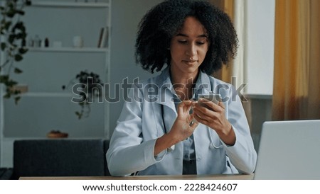 African doctor woman therapist use mobile phone app texting message medical recommendation for patient consultation online distance treatment medicine in pandemic time modern technology and healthcare Royalty-Free Stock Photo #2228424607