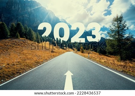 2023 New Year road trip travel and future vision concept . Nature landscape with highway road leading forward to happy new year celebration in the beginning of 2023 for fresh and successful start . Royalty-Free Stock Photo #2228436537